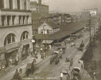 Market Street on a typical Sunday morning. The present Market House stands on the same site. Note the man coming down the street carrying two barrels, also the beer wagon in the center.